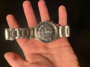 Citizen herrklocka med metallarmband - Säljer en snygg Citizen herrklocka med robust silverfärgat metallarmband och mörk urtavla med flera funktioner. Klockan har rund boett, tydliga visare och datumvisning. Perfekt för dig som gillar stilrena accessoarer med teknisk känsla.