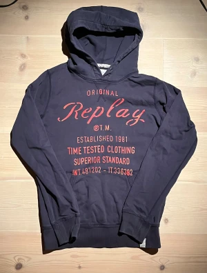 Mörkblå Replay hoodie med röd print - Tja! Säljer denna feta Replay hoodie. Trycket är lite slitet annars är det inga fel på den. Storlek L/M. Vid minsta fråga eller fundering hör av er🤝🏼