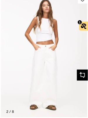 Vita wide jeans med hög midja - Säljer ett par vita jeans från Pull&Bear med riktigt breda ben och hög midja. De har klassisk femficksdesign, raka sömmar och stängs med knapp och dragkedja. Perfekta för dig som gillar en loose och trendig look. Har en hög midja men har använts som low waist baggy jeans säljer pågrund av fel storlek. Köpta för 400. Använda 2 ggr.