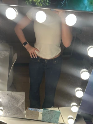 Levis mörkblå bootcut jeans - Säljer ett par klassiska Levis 517 jeans i mörkblå tvätt. De har låg midja, bootcut-ben och snygga kontrastsömmar. Jeansen är i ett robust jeanstyg och har den ikoniska Levis-lappen bak i midjan. Perfekta för dig som gillar en tidlös och chill look. 