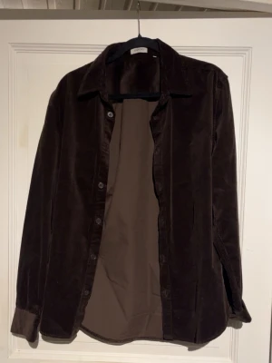 Brun manchesterovershirt från Sandö. S/M - Säljer en brun manchesterovershirt från Sandro med klassisk krage och knäppning framtill. Säljer den då den aldrig riktigt används, därav också är den i helt nytt skick då jag kanske använt den max 1-2 gånger. Hör av er vid funderingar🙌 (Nypris : 899:-)