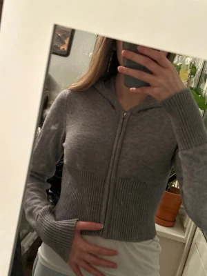 Grå hoodie med dragkedja från Gina Tricot - Jätte mysig stickad tröja/kofta med luva och dragkedja. Storlek 158-164. Oanvänd, prislappen är dock bort tagen