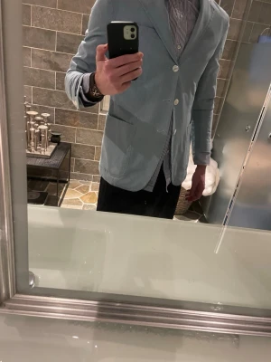 Ljusblå kavaj från Polo Ralph Lauren - Denna fina kavaj är aldrig använd och pristagg på. Säljer enbart för att den är lite kort i armarna för mig. Men de gör ont att behöva sälja denna helt oanvänd.