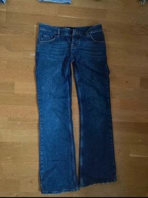 Blå bootcut jeans från The Kooples - Snygga blå jeans från The Kooples i klassisk bootcut-modell. Normal passform och är gjorda i slitstarkt denim. Perfekta för dig som gillar en tidlös look med lite vidare ben.