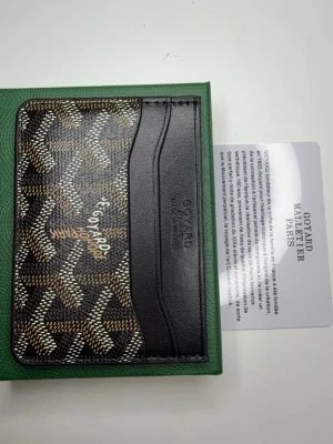 Korhållare plånbok - Fin plånbok i svart färg med en lyxig märke, fin för adda på stilen. Finns fler inne och andra färger ifall man är intresserad av att köpa andra färger eller fler av samma färg.