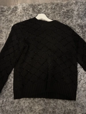 Svart glitter stickad tröja från ONLY - Säljer en svart stickad tröja från ONLY i storlek XS. Aldrig använd men skitsnygg. 