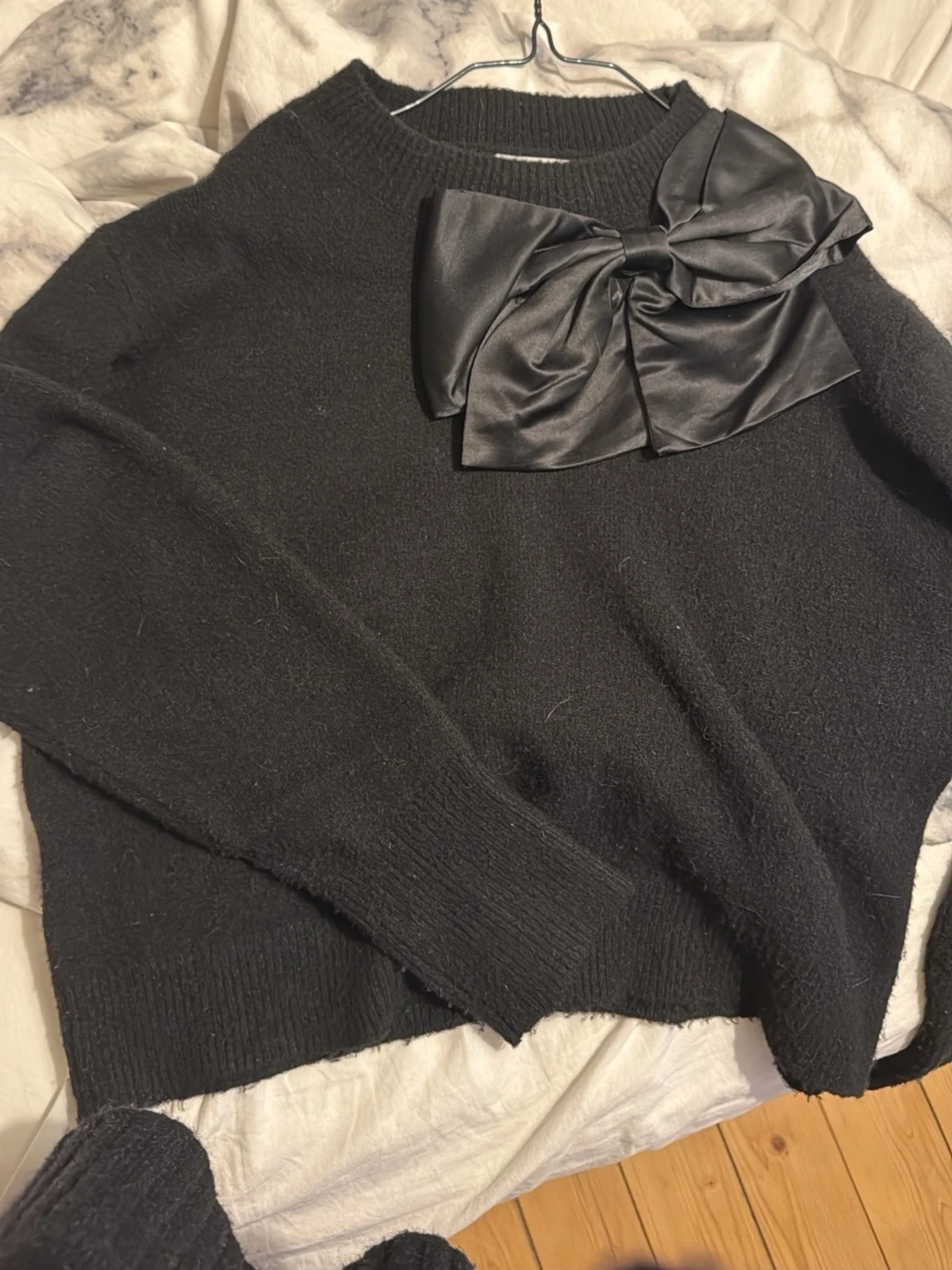 Svart stickad tröja med stor rosett