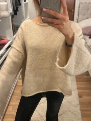 Beige oversized stickad tröja - Mysig beige stickad tröja med oversized passform och vida, långa ärmar. Perfekt för kyliga dagar när du vill ha något bekvämt. Passar bra till jeans eller leggings för en avslappnad look. Tagit bort storlekskappen i nacken då den syntes men annars inga tecken på användning 🥰