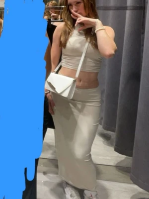 Beige croppad linnetopp och kjol från SHEIN - Säljer en stilren croppad linnetopp och kjol från SHEIN i beige färg. Toppen är ärmlös med rund halsringning och har en tight passform som framhäver midjan, medan kjolen är tight som framhäver min pasform. Perfekt för varma väder.