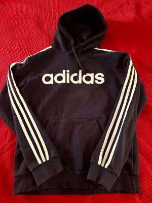 Hoodie Adidas  Unisex S , marinblå  - Hoodie i bra skick S , bomull , bredd 45cm, längd 67cm 