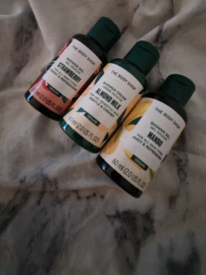 The Body Shop duschgel 3-pack - Säljer ett 3-pack duschgel från The Body Shop i dofterna Strawberry, Almond Milk och Mango. Flaskorna är små, perfekta för resan, och har färgglada etiketter som matchar doften. Alla är veganska och innehåller 60 ml vardera.