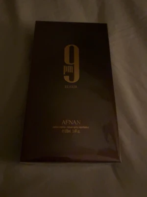Afnan 9pm Elixir parfym 100ml - Afnan 9pm Elixir är en parfym i elegant mörkbrun förpackning med guldiga detaljer. Flaskan rymmer 100 ml och har en lyxig känsla. Perfekt för dig som gillar exklusiva dofter och snygg design. Parfymenen är öppnad men är helt oanvänd och orörd. köpt för 450 kr.