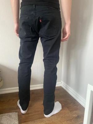 Svarta skinny jeans från Levi's - Svarta 512 slim fit jeans från Levi’s, perfekta för en stilren och modern look. Storlek W31 L32. Mycket bra skick, svag runt märke på ena fickan från snusdosa. Postar inom 24h📦