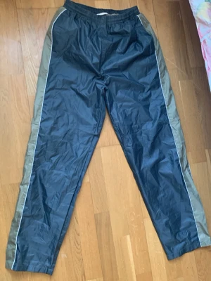 Täckbyxor/trackpants  - Byxorna har resår i midjan och meshfoder på insidan för extra komfort. Perfekta för kalla dagar när du vill hålla dig varm och torr. Storlek L men passar även S-M