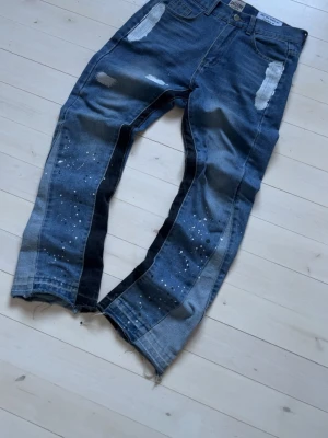 Gallery dept. flare - Gallery Dept Flared Jeans – Distressed / Paint Splatter  Authentic Gallery Dept flared jeans in blue denim. Features signature distressed details on the thighs, subtle paint splatter effects on the legs, and a flared fit at the bottom for a bold streetwear look. High-quality denim with great structure and a unique vintage vibe.  • Brand: Gallery Dept • Fit: Flared • Color: Blue denim • Details: Distressing, paint splatter, raw hems • Condition: Very good (no major flaws) • 100% authentic  Perfec