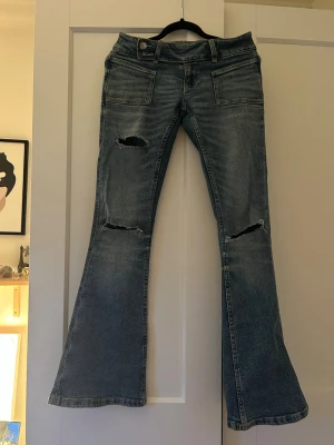 Low waist bootcut jeans  - Säljer ett par blå skit snygga low waist jeans med slitningar!😍
