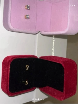 2 askar med 2 örhänges par  - 💠Guldpläterade örhängen (ena) den andra är gulfärgad sterling silver 925. Med stämplar. Askar medföljer . Skickas via PostNord med kvitto & 🧾 spårbar länk om önskas. Nya i förpackningar. Passar som gåva. Mini size. 