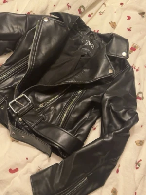 Svart skinnjacka från Zara - Svart kroppad skinnjacka från Zara. 499kr ny har jag för mig. Inget fel på den förutom lite nött längst fram på ärmarna. Se andra bilden