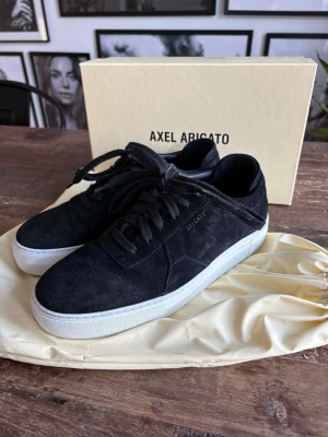 Axel arigato  - Riktigt snygga Axel Arigato sneakers! Perfekta skor för alla årstider – stilrena, bekväma och lätta att matcha till både vardag och fest.  Skorna är tillverkade i en lyxig kombination av mocka och skinn, vilket ger en exklusiv look och hög kvalitet. Väl omhändertagna och i fint skick.  ✔️ Originalkartong medföljer ✔️ Inpåse/dustbag ingår ✔️ Tidlös design från Axel Arigato  Ett riktigt kap för dig som vill ha sneakers som både känns och ser premium ut 😮🔥 Hör av dig vid intresse! 