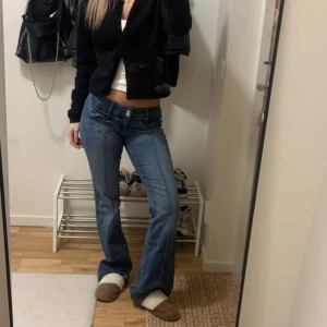 Blå bootcut jeans med låg midja - Snygga blå bootcut jeans med låg midja och klassiska fem fickor. Jeansen har en lätt tvättad look och vida ben nertill. Perfekta för en avslappnad och trendig stil.