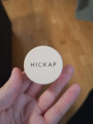 Hickap Fire Eyes Cream Shadow - Krämögonskugga från Hickap i nyansen Intergalactic. Kommer i en liten rund burk med beige lock och svart text. Skuggan har en skimrande, ljus champagnefärg som ger en glansig finish. Perfekt för dig som gillar glow och vill ha en enkel applicering.