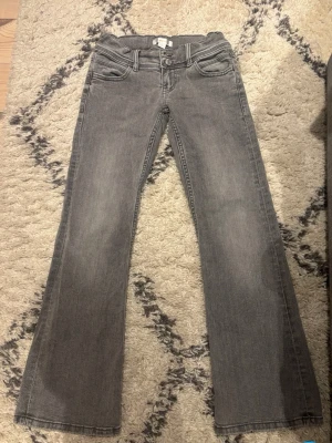 low waist jeans 146 - Säljer ett par grå jeans med som är bootcut och en snygg stjärna broderad på ena bakfickan. Jeansen har en ljus tvätt och klassisk femficksdesign. Perfekta för dig som vill ha en chill men ändå unik look. De går att justera i midjan💕