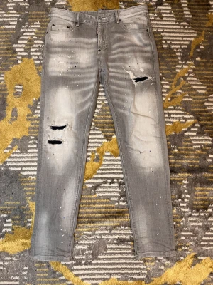 Grå Dsquared Jeans - Säljer ett par feta byxor som är grå från dsquared som är knappt använda (bara till ett bröllop). Inte min stil men dom passar grisch men även ortenstil. Lägre pris vid snabb affär. VID FLER FRÅGOR ELLER SÅ DET ÄR BARA O HÖRA AV SIG. Dom passar om man är ungefär 74kg och 185cm lång.