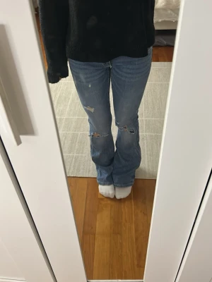 Blå bootcut jeans med slitningar - Säljer dessa blåa jeans med låg midja och slitningar❤️använda fåtal gånger! 
