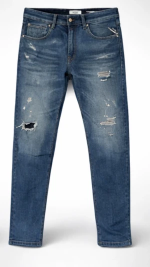 Blå Replay Jeans - Säljer ett par blå jeans med raka ben och slitna detaljer samt hål på låret. Jeansen har klassisk femficksdesign och är gjorda i jeansmaterial. Perfekt för dig som gillar en avslappnad och cool stil.