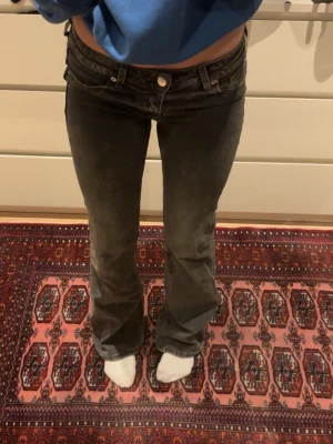 Grå bootcut jeans med låg midja - Säljer ett par grå jeans med bootcut och låg midja, det finns lite slitningar på ena benet längst nere (bild 4) skriv gärna innan köp 💕💕💕🙌🙌☀️