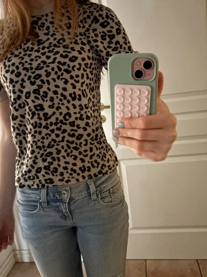 Beige leopardmönstrad t-shirt - ‼️PRISET KAN DISKUTERAS‼️ STROLEK 146-152!! Passar mig som använder xs/s. Säljer en beige t-shirt med svart leopardmönster. T-shirten har korta ärmar och rund halsringning med ribbade muddar. Materialet är mjukt och skönt. 