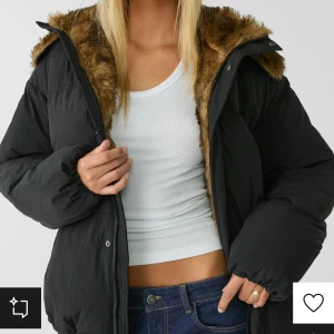 Svart pufferjacka med fuskpäls - Snygg svart pufferjacka med fuskpäls på huvan. Jackan har dragkedja och är perfekt för kyliga dagar. Den har en avslappnad passform och är lätt att matcha med olika outfits. Produkt från Stradivarius i storlek L, aldrig använd. Pris kan diskuteras! Original pris: 859kr
