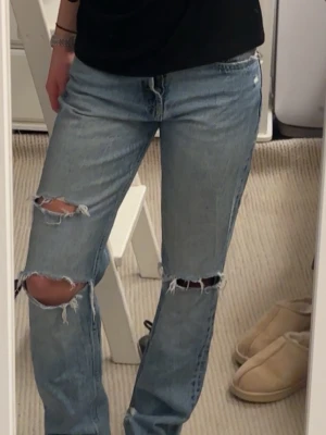 Zarajeans - Säljer ett par ljusblå jeans från Zara i storlek 36 med snygga slitningar och hål vid knäna. Perfekt för dig som letar efter jeans med hål💙🙌Skulle säga passar även dig som brukar ha 32-34!