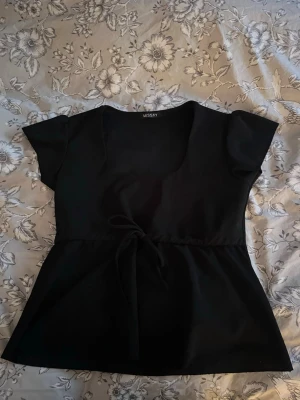 Svart topp med knyt från Missay - Säljer en jätte snygg svart topp från Missay som inte kommer till användning längre🫰