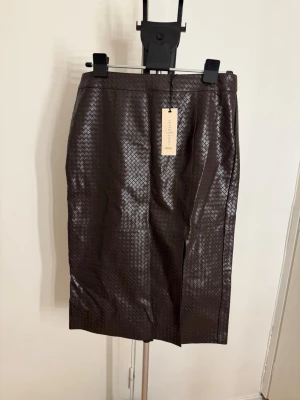 Brun långkjol från Love & Roses. 100%viskos - 100% viskos med PU-beläggning. Nypris 970kronor 