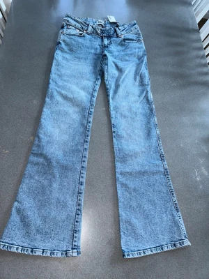 Nya jeans med superlåg midja bootcut Paris Ebroidery full length storlek S - Nya med lapparna kvar. Nypris 400kr.  Jeans i stretchdenim. Smal passform, superlåg midja och bootcut. Jacron patch Bootcut Smal passform Broderi på bakfickan Superlåg midja Gylf med dragkedja Förlängt midjeband med dubbla knappar