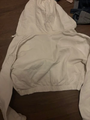 Vit croppad huvtröja  - Vit croppad huvtröja från Lindex. Fint skick, men färgen har släppt lite från dragkedjan. 