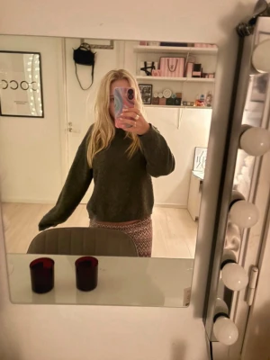 Mörkgrå stickad tröja - Mysig mörkgrå stickad tröja med lång ärm och avslappnad passform. Perfekt för kyliga dagar och enkel att matcha med olika outfits. Tröjan har en klassisk rund halsringning och är riktigt skön att ha på sig.