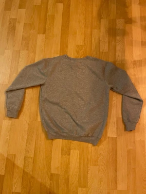 Grå Nike Jordan sweatshirt XL - Säljer en grå crewneck sweatshirt från Nike med Jordan-tryck framtill. Tröjan har en stor röd Jumpman-logga och svarta bokstäver. Klassisk passform med ribbade muddar vid ärmar och midja. Perfekt för dig som gillar streetwear och sportig stil.passar om du är ca 165-175,vid snabbt köp är jag villig att gå ner i pris