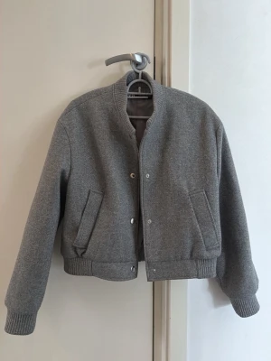 Grå bomberjacka i ull - Säljer en stilren grå bomberjacka från Zara i mjuk ullmix i storlek xs.  I perfekt skick, endast använd 1 gång. 