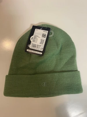 Beaniemössa - Säljer en jättefin beaniemössa från märket Champion. Den är helt ny och oanvänd med prislappen fortfarande på. Skriv vid frågor och funderingar.