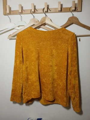 Gul mjuk stickad tröja - Säljer en supermjuk och mysig gul stickad tröja med lång ärm. Tröjan har en avslappnad passform och är perfekt för dig som gillar en varm och skön stil.