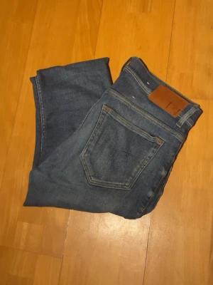 Blå tiger of sweden jeans ( slim fit ) - Säljer ett par blå slim fit jeans från TOS med klassisk femficksdesign och snygg läderpatch i midjan. Jeansen har en smal passform och är tillverkade i mjukt denimtyg som sitter skönt. Hör av er vid frågor✌️