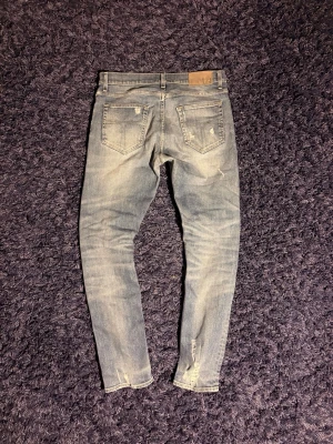 Tiger of Sweden jeans - Säljer ett par ljusblå skinny jeans från Tiger of Sweden med slitna detaljer och klassisk femficksdesign. Sitter på skönt och har mycket feta detaljer som dess tvätt och slitningar. Hör av er vid minsta fundering!