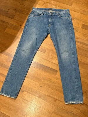 J.Lindberg blå raka jeans - Klassiska J.Lindberg jeans med rak passform och fem fickor. Jeansen har ljus tvätt och råa, fransiga benslut för en avslappnad vibe. 