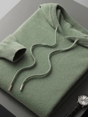 Grön hoodie i mjuk ullmix - Snygg grön hoodie med huva. Tillverkad i en mjuk ullmix som känns riktigt skön mot huden. Storlek M men väldigt liten i passform, passar max S. Perfekt för dig som vill ha en stilren och bekväm look.