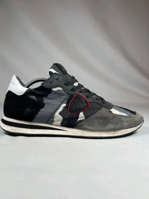 Philippe Model - Snygga sneakers från Philippe Model med grå, svart och vit camouflage-mönstrad ovandel. Skicket är perfa, knappt använda. Storlek 45 men funkar på 44. Startpriset börjar på 1449 men kan diskuteras. Nypris är på över 3000kr så passa på