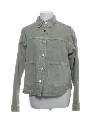 Grön jeansjacka från ZARA - Snygg ljusgrön jeansjacka från ZARA med klassisk krage, stora framfickor och silverfärgade knappar. Jackan har en avslappnad passform och är tillverkad i slitstarkt jeanstyg. Perfekt för dig som vill ha en stilren och trendig look.