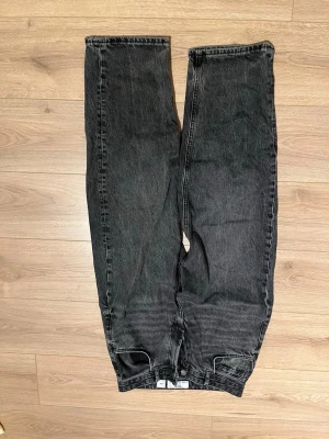 Svarta raka bershka jeans i loose fit - Säljer ett par svarta bershka jeans med rak passform och loose fit. Jeansen har klassisk femficksdesign och är tillverkade i kraftigt denimtyg. Perfekta för dig som gillar en avslappnad och trendig stil.