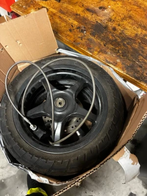 Svarta fälgar med däck till moped - Säljer två svarta aluminiumfälgar med monterade däck, troligen till moped eller scooter. Fälgarna har tre ekrar och bromsskivor monterade. Passar dig som behöver reservdelar eller vill byta ut dina gamla hjul.